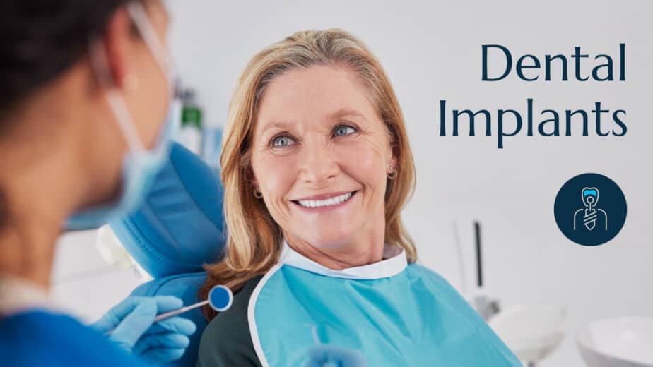 A woman at the dentist getting her teeth examined by a dentist with the words dental implants on the image.