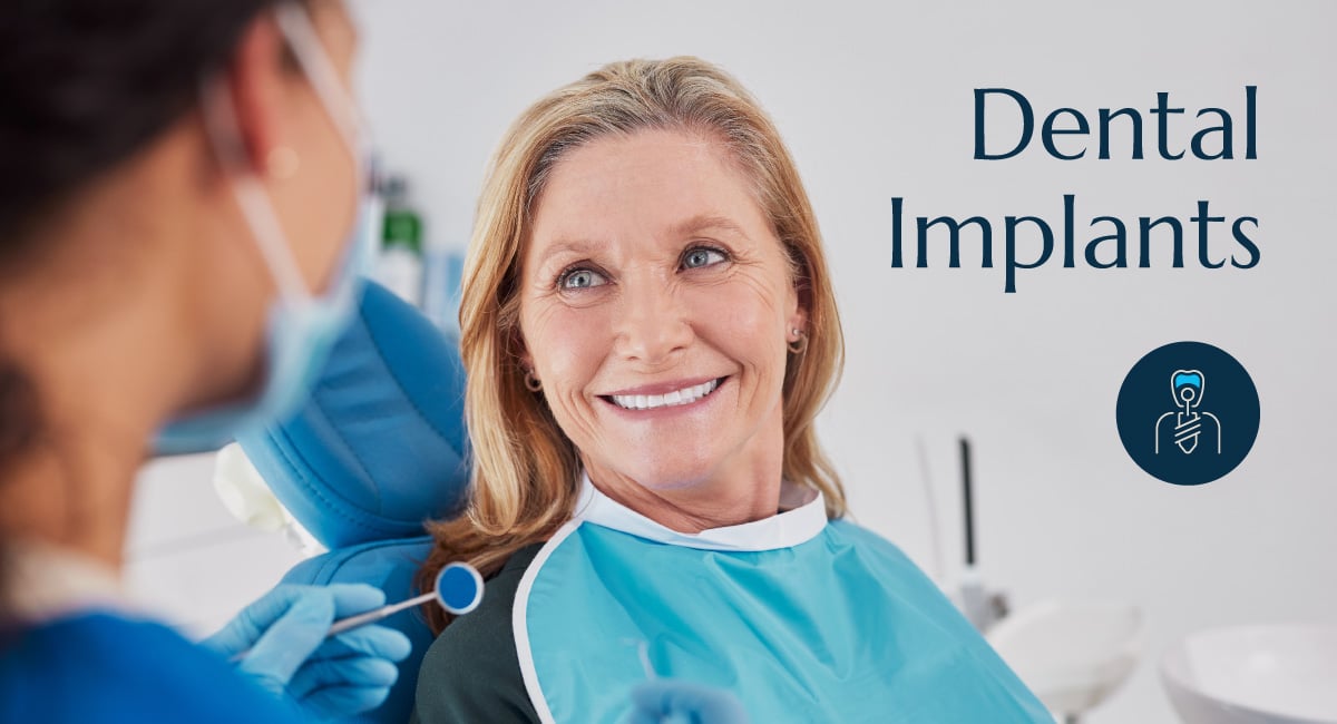 A woman at the dentist getting her teeth examined by a dentist with the words dental implants on the image.